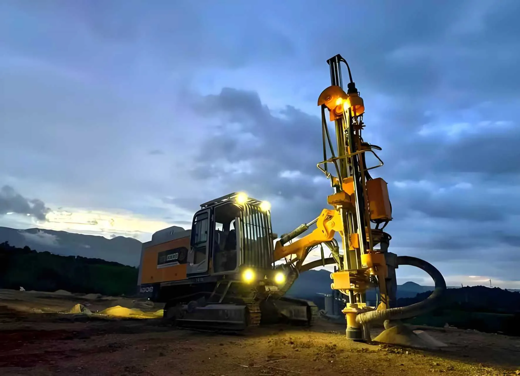 Open-pit drilling rig on site at dusk